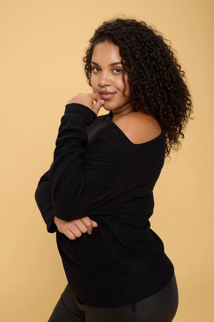 woman wearing black brushed knit off shoulder sweaters on black pants