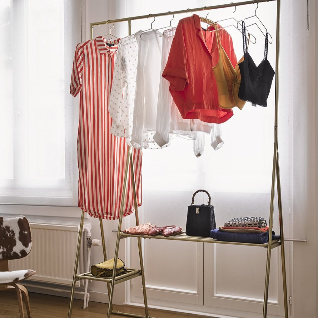 open wardrobe in brass with apparel