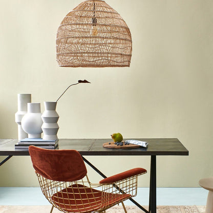 modern setting of desk, brass chair and rattan basket pendant light