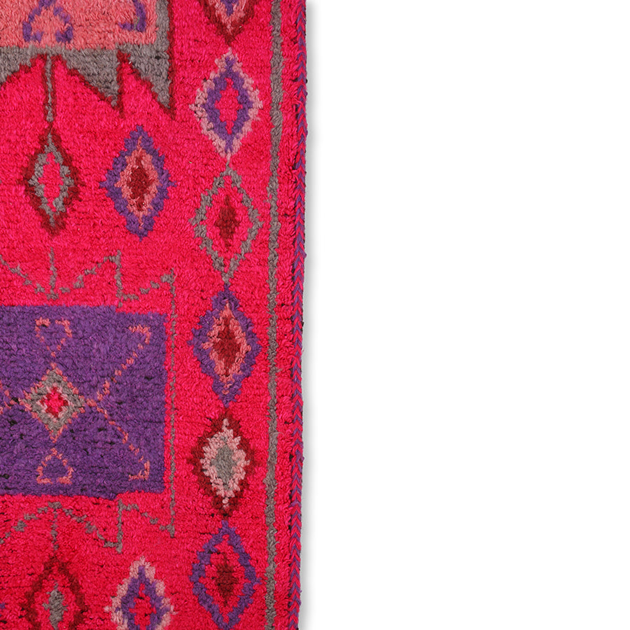 detail of bright pink woolen runner with purple red and gray patterns