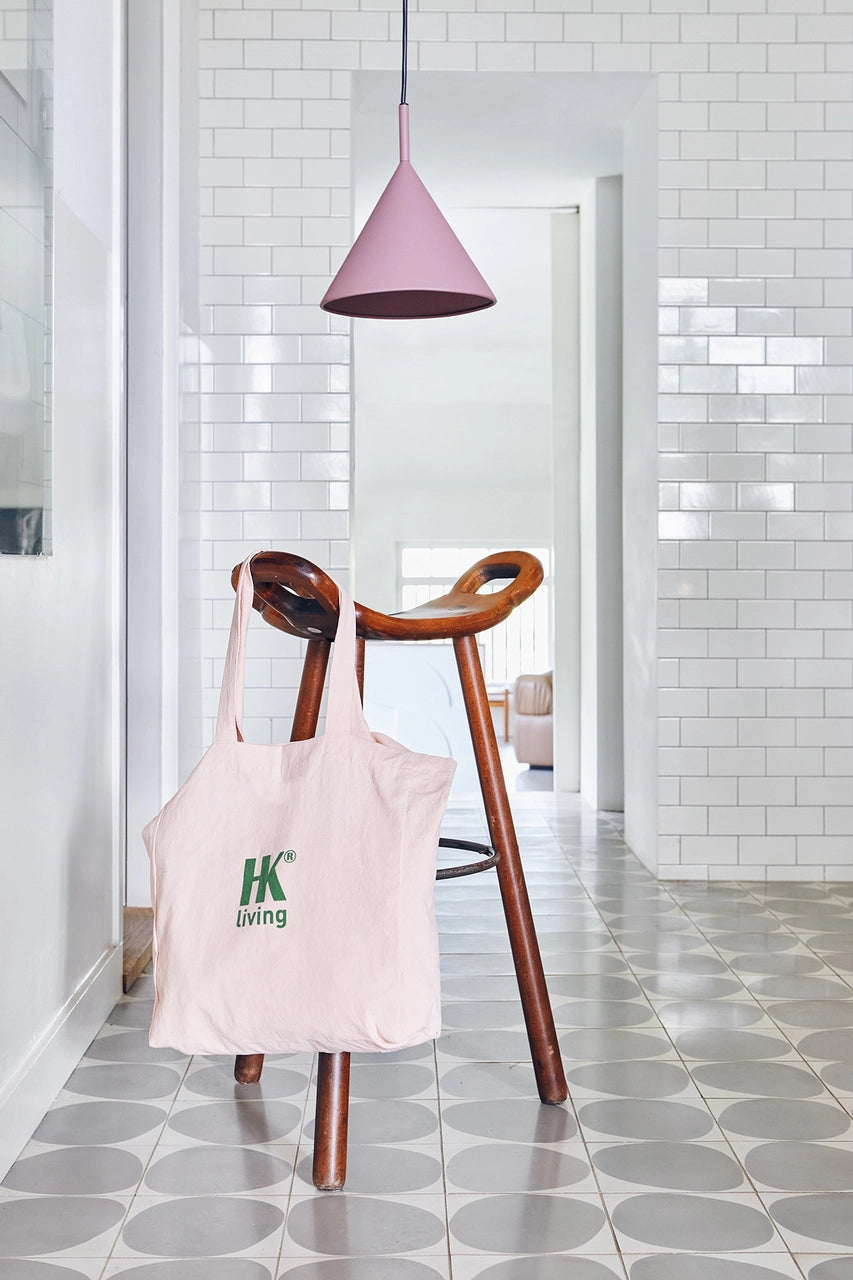 matte purple metal triangle single pendant light in a kitchen with a wooden bar stool