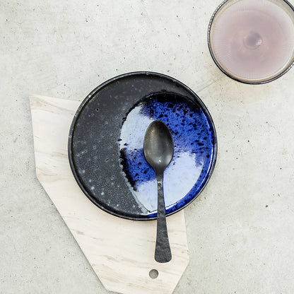 cobalt blue and black dessert plate and a black spoon