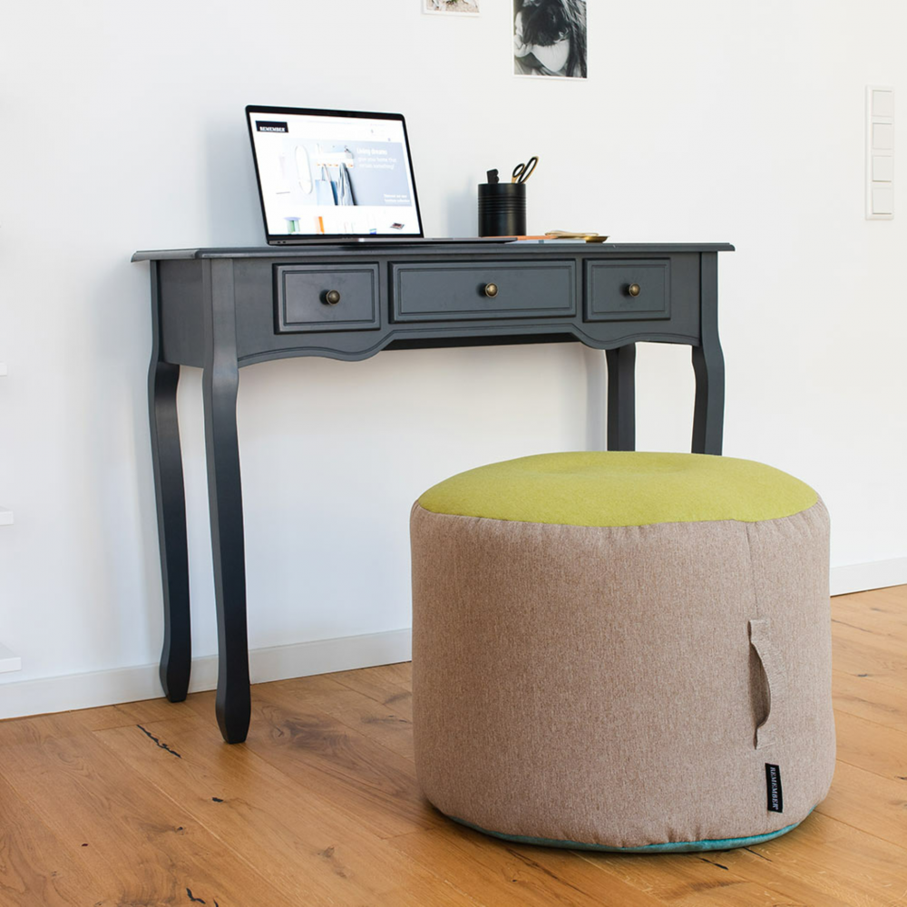 tricolor pouf in beige, green and blue at wooden desk