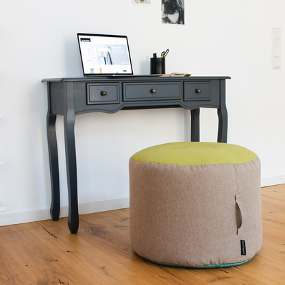 tricolor pouf in beige, green and blue at wooden desk