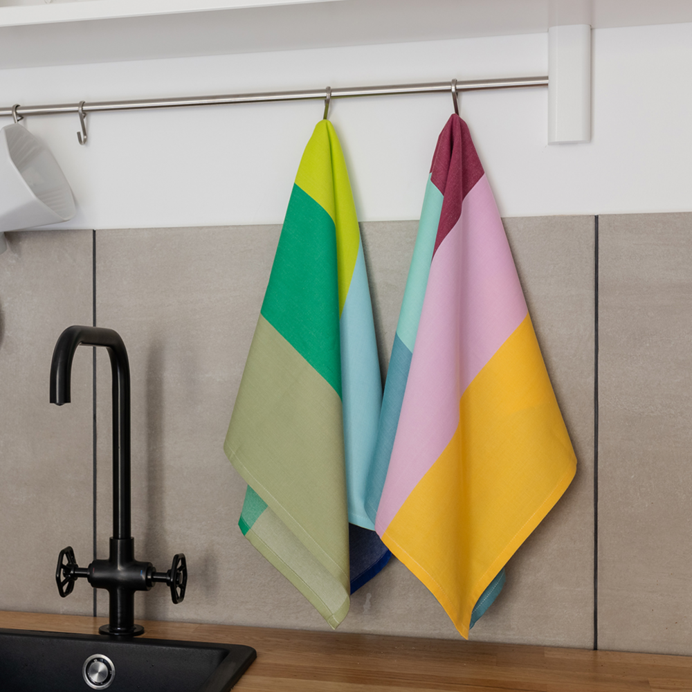 two striped kitchen towels made of colorful cotton hanging in a kitchen