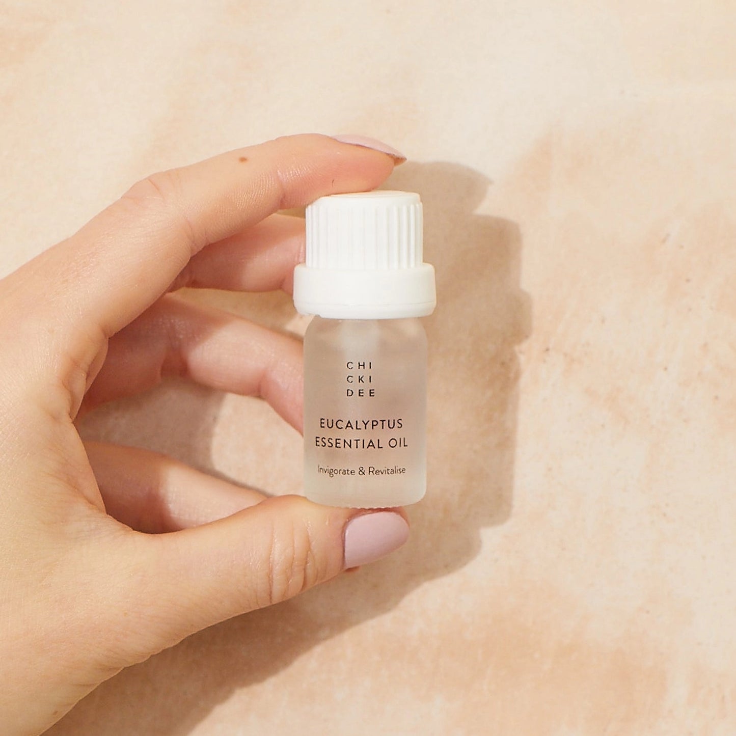 hand holding a small glass bottle with eucalyptus essential oil