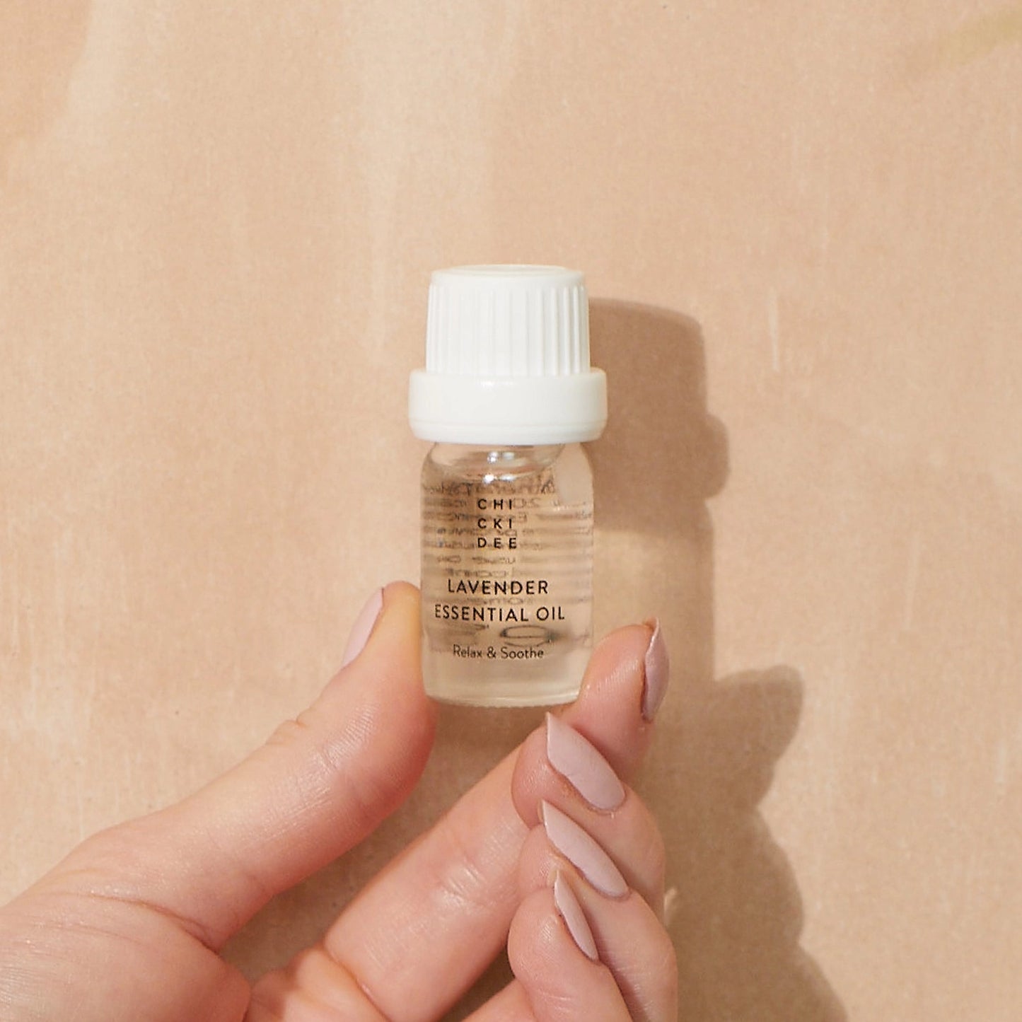 hand holding a 5ml glass bottle with essential lavender oil
