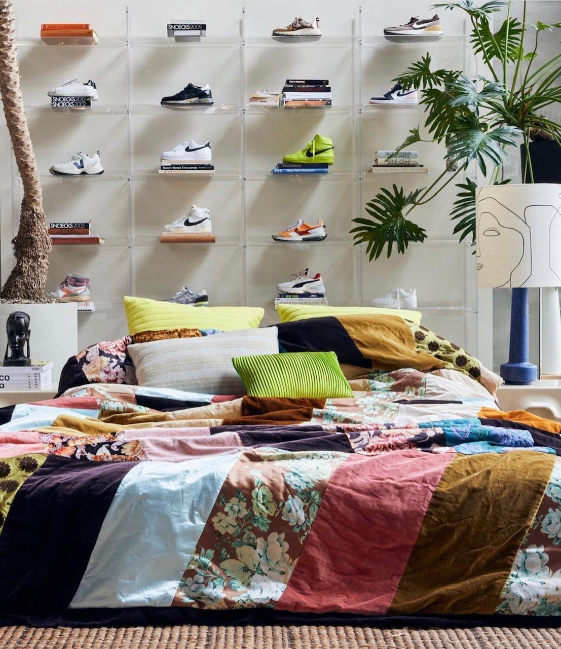 display of Nike sneakers behind a bed filled with HKliving USA pillows