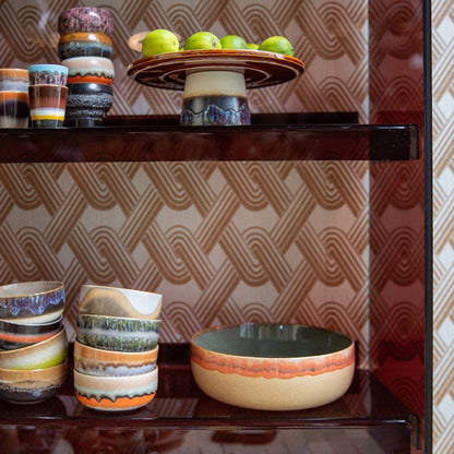 retro style cake stand with limes in brown acrylic open shelving cabinet