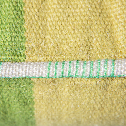detail of yellow and green handwoven woolen lumbar pillow with piping