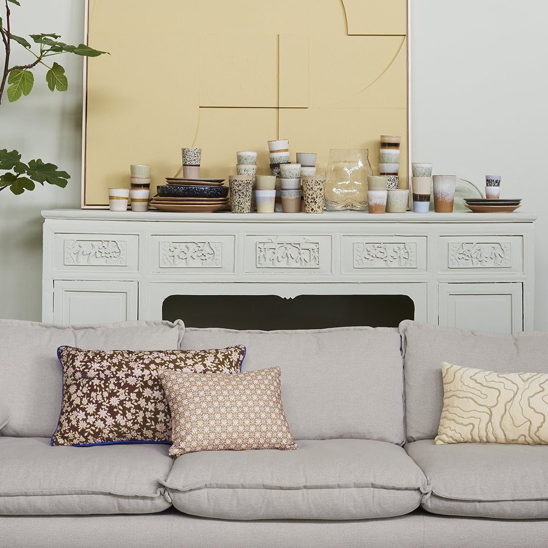 double sided lumbar pillow in brown and green colors with blue trim on a sofa with other pillows