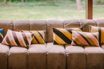 caramel toned velvet lumbar pillow with other pillows on sofa