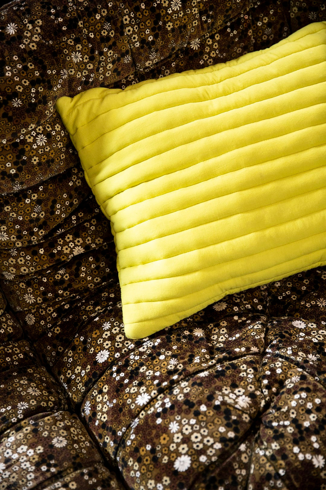 bright yellow throw pillow on brown sofa