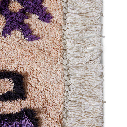 salmon colored bath mat rug with brown and purple design and fringes