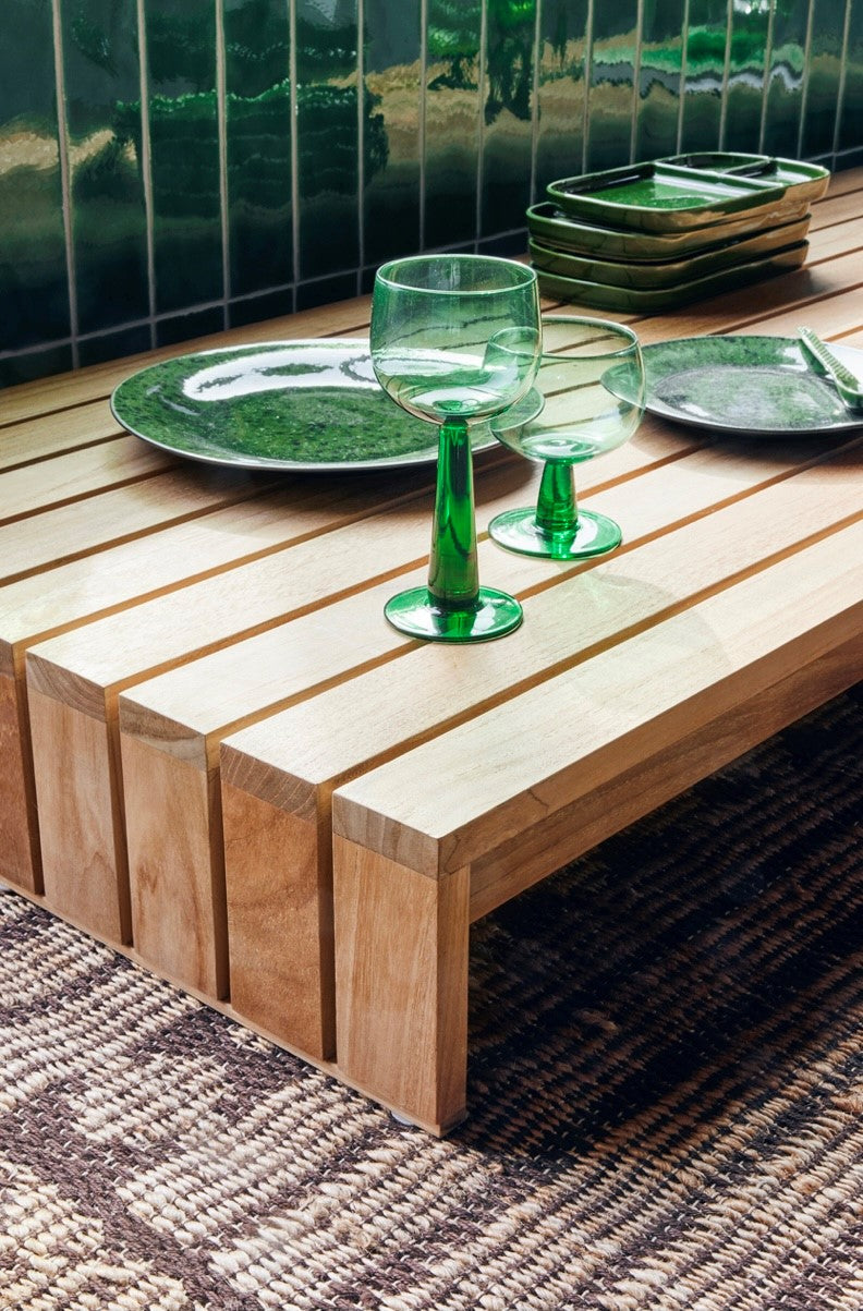 fern green high and low stem wine glass on wooden table