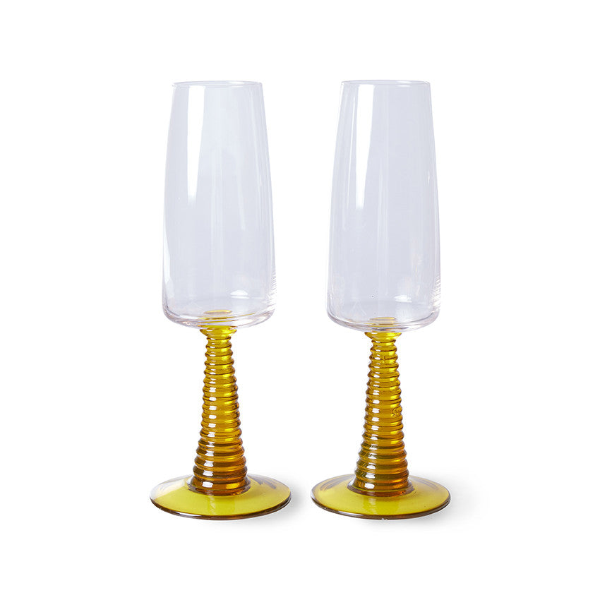 two champagne glasses with ochre colored stem
