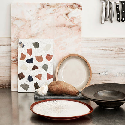 dinner plate frost in kitchen with colored cutting board and marble board