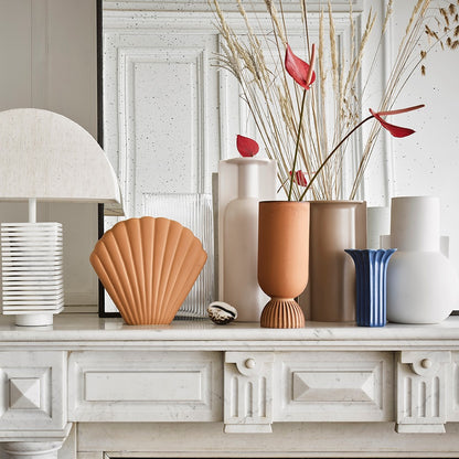 group of vases in neutral colors next to a lamp with marble base