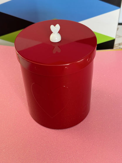 red metal storage jar with raised hearts and white heart on top of lid