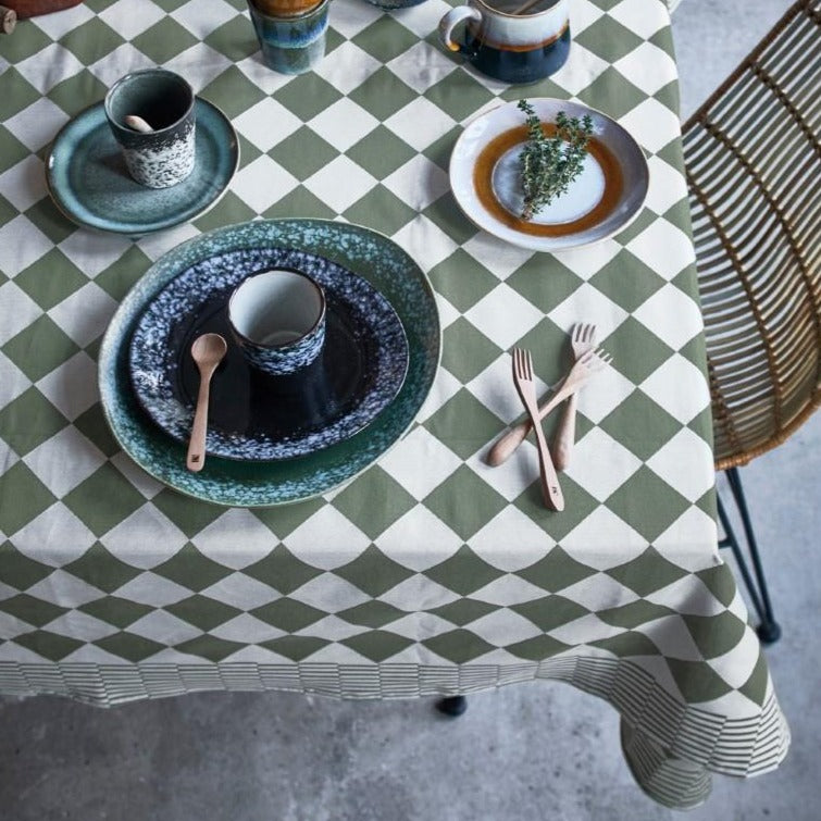 table with traditional green and white checkered table cloth and green and black plates