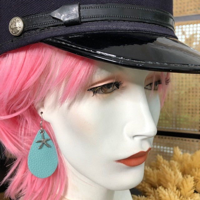 aqua blue, leather tearshaped earring with a silver sea star worn by woman with pink hair