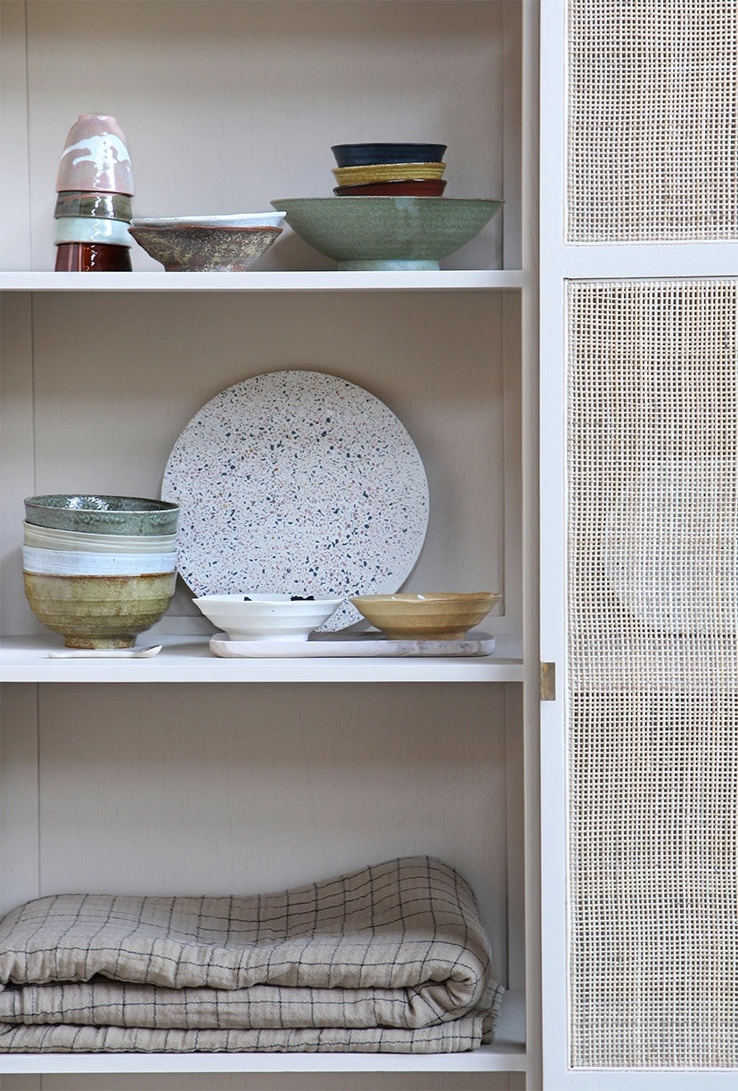 cabinet with tableware including a stack of 4  Japanese tea cups