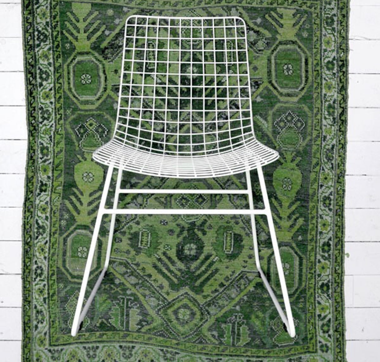 White metal wire dining chair with green rug
