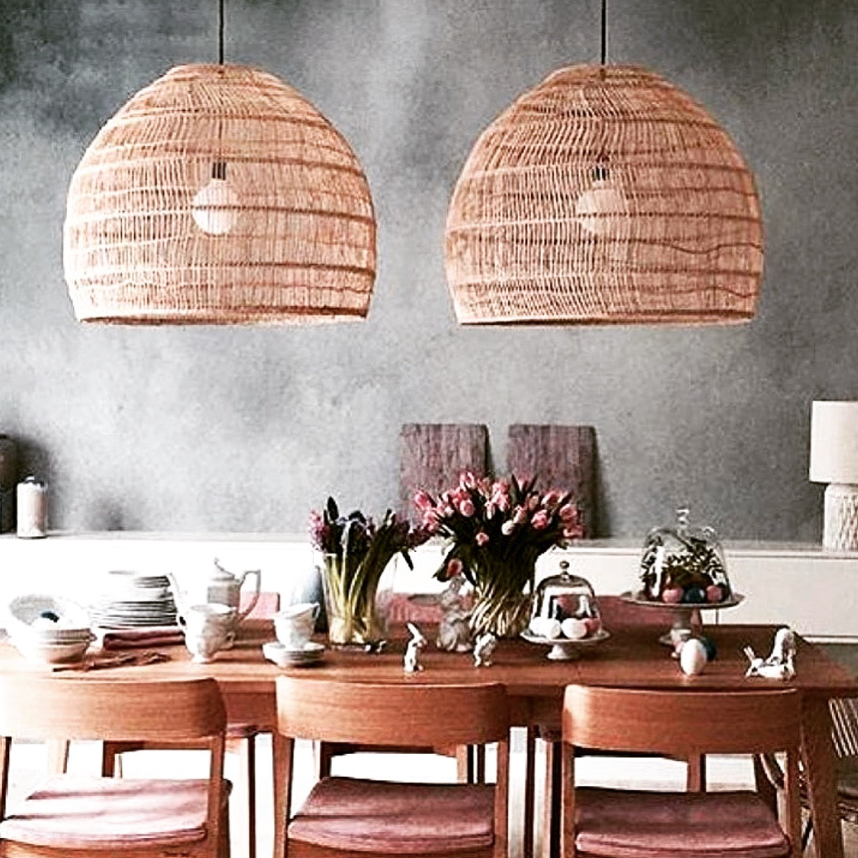 Hand woven large wicker basket pendant light above a dining table