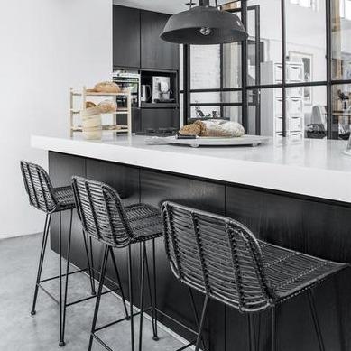 Black and white kitchen with natural black rattan bar stools in Nordic style