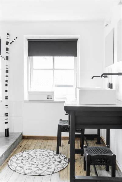 Black and white styled bathroom with round bath mat