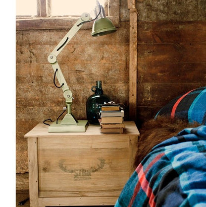 cabin look with wooden trunk used as nightstand filled with books and a lamp