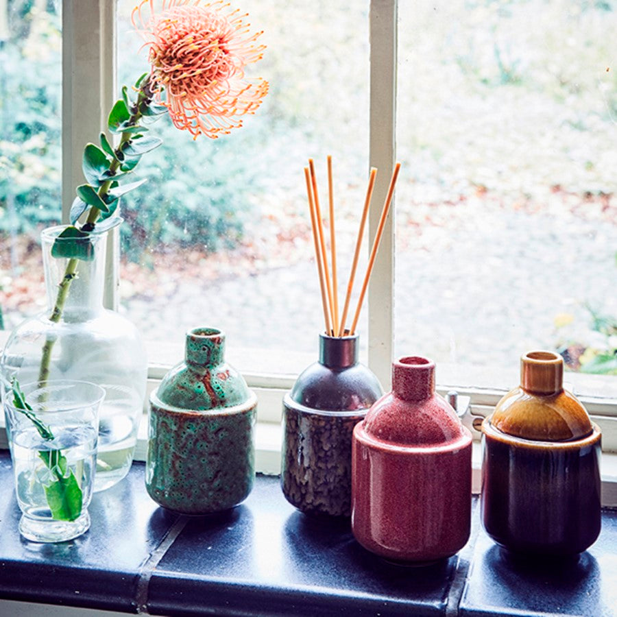 window with group of ceramic pots that hold home fragrance