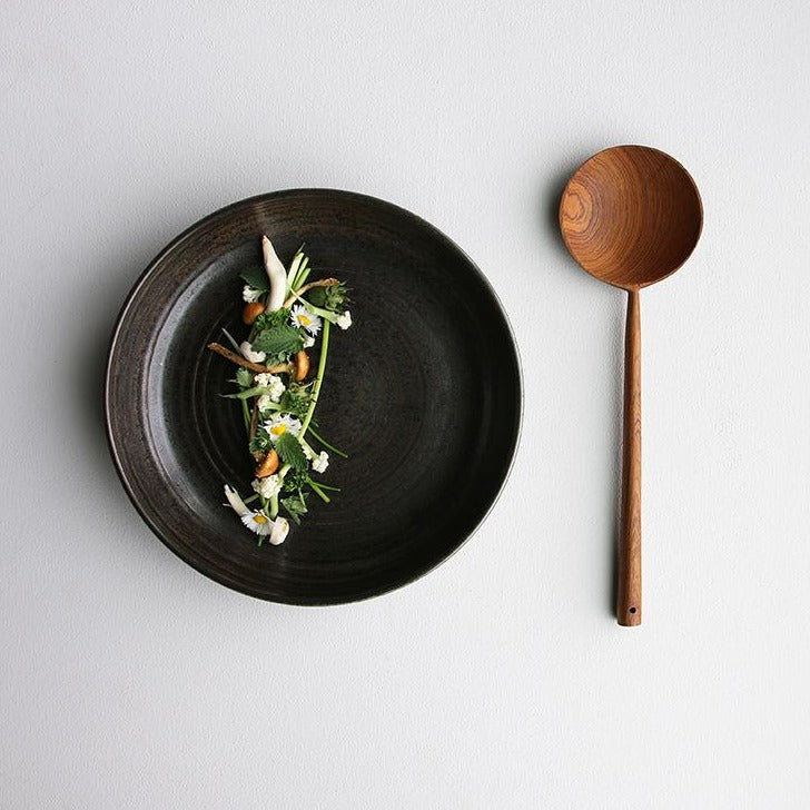 black ceramic plate and teak wooden spoon