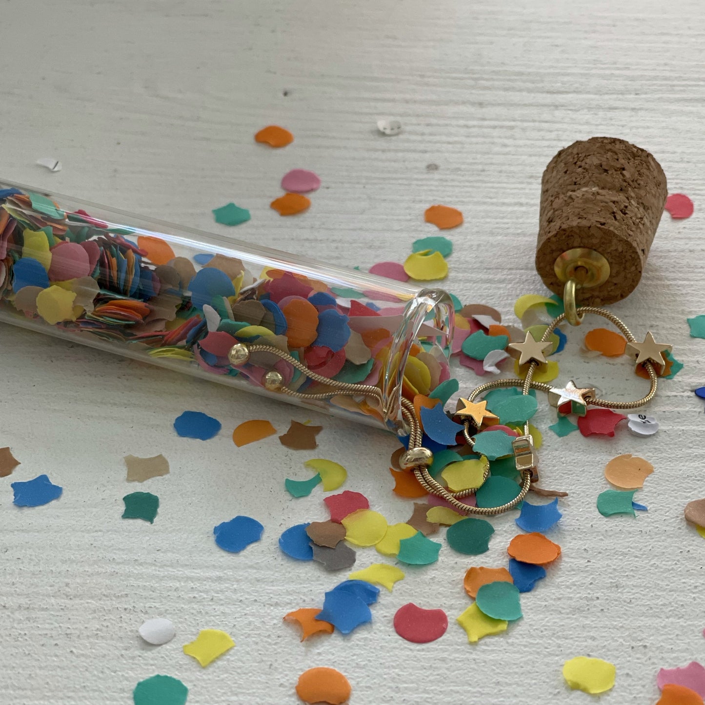 gold star bracelet in glass tube with confetti