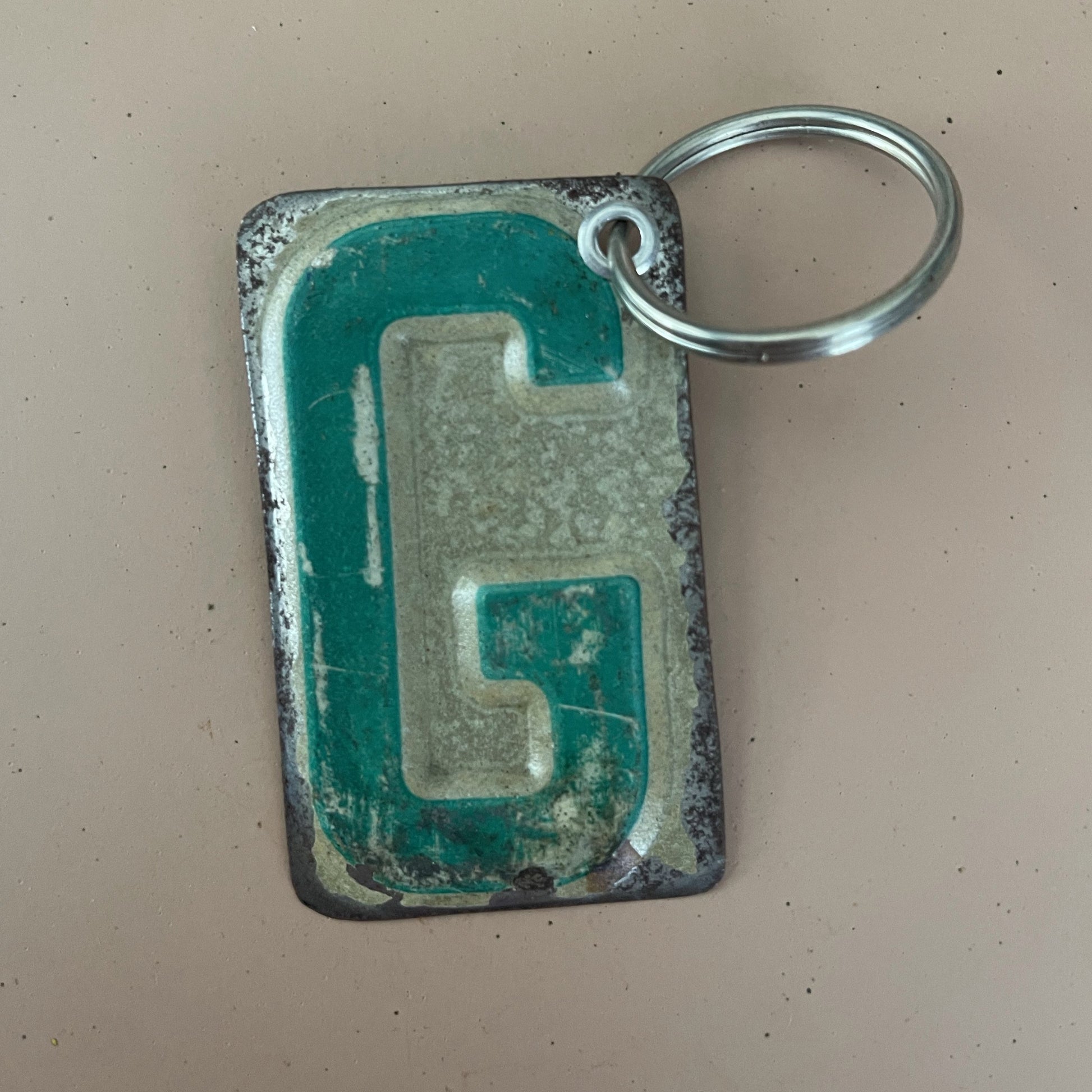 key chain fob with letter G cut out from license plate