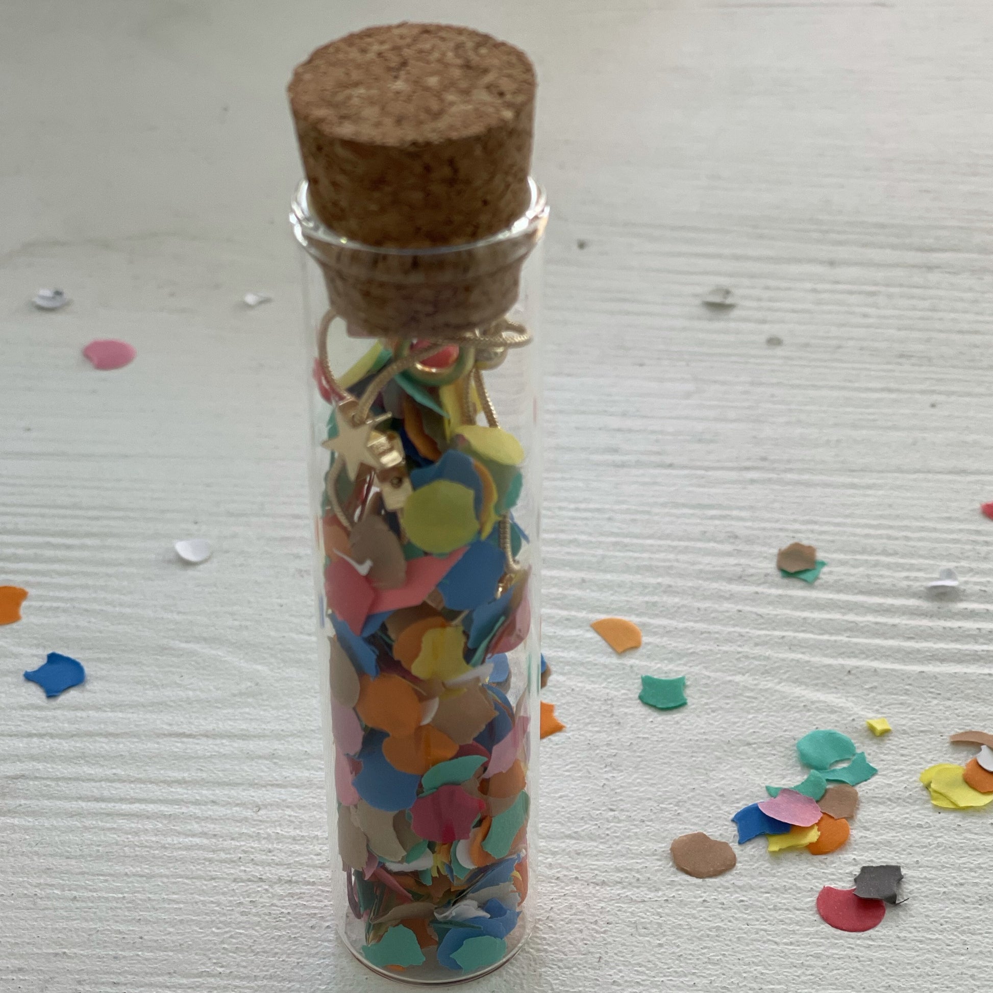 gold star bracelet in glass tube filled with confetti