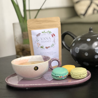 pastel colored cup with tea, macrons and vana tisanes tea