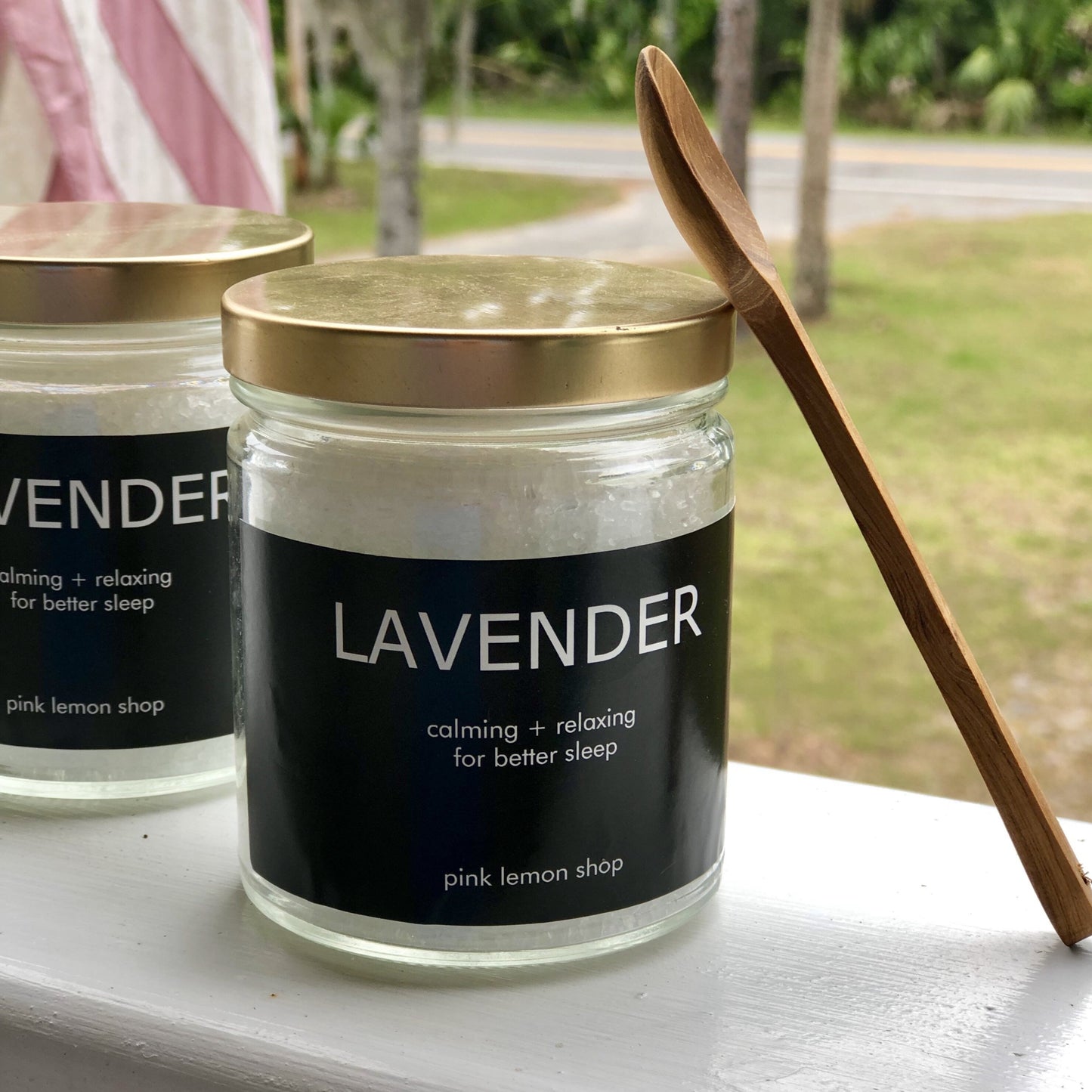 Lavender smelling bath salt in a glass jar with a wooden spoon