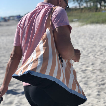 handsome man with pink shirt and striped beach tote