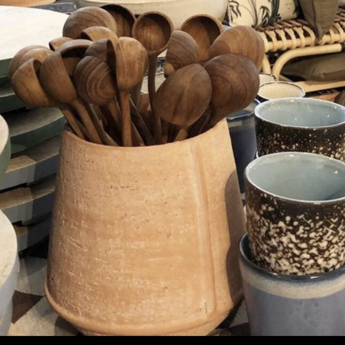 terracotta pot filled with wooden spoons