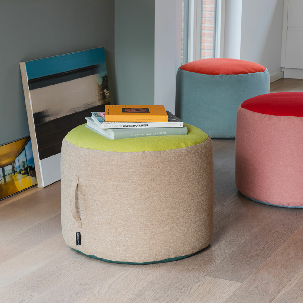 tricolor pouf in beige, green and blue with books on top