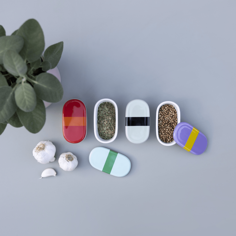 4 porcelain oval boxes with blue lilac green and red  lids with black stripe with fresh herbs