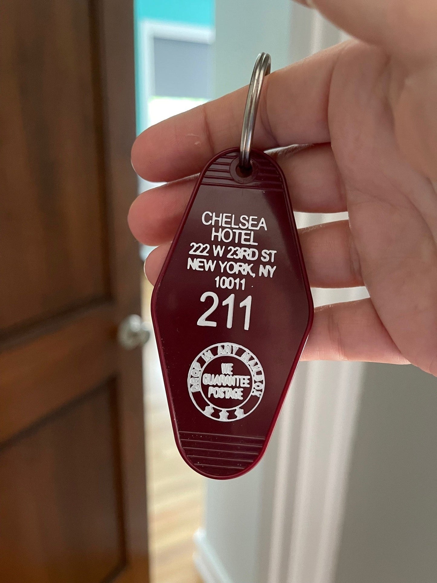 maroon colored plastic hotel key FOB with Chelsea Hotel NY address and room number 211