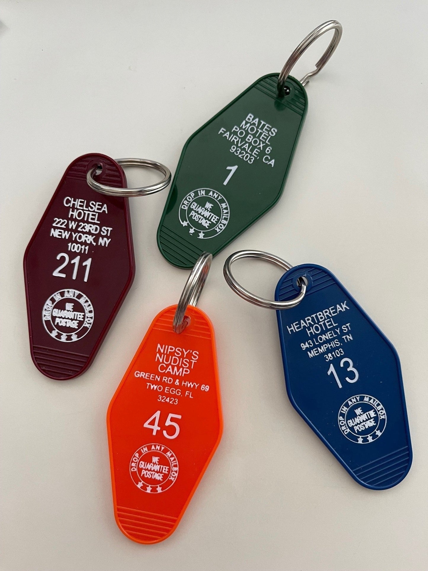 maroon, green, orange and blue plastic motel key FOB with metal ring