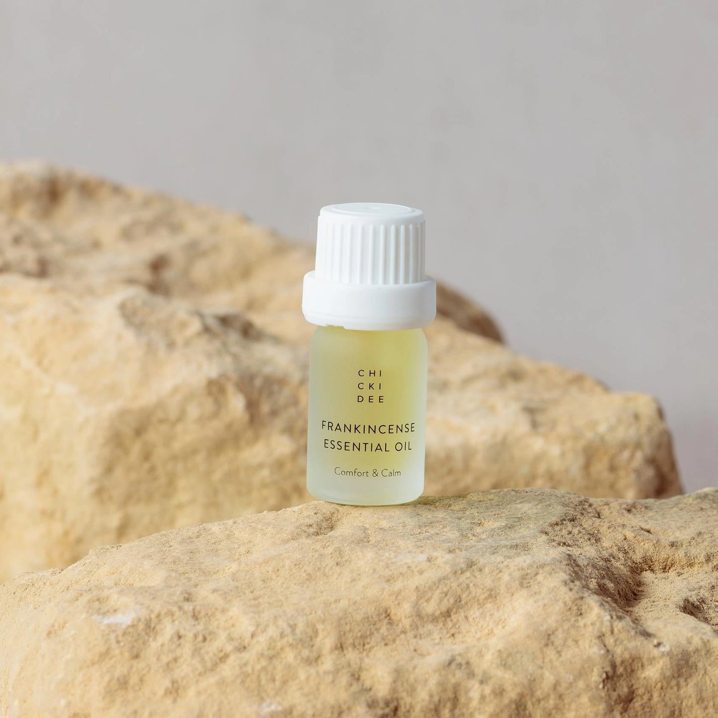 5 ml glass bottle with Frankincense essential oil on a rock