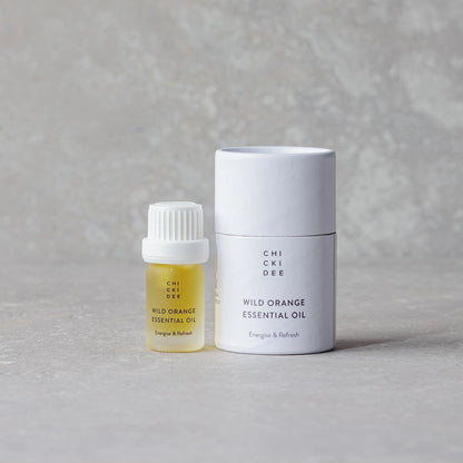 small glass bottle with wild orange essential oil and white box
