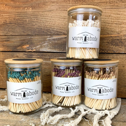 green, purple brown and white colored matches in glass jars