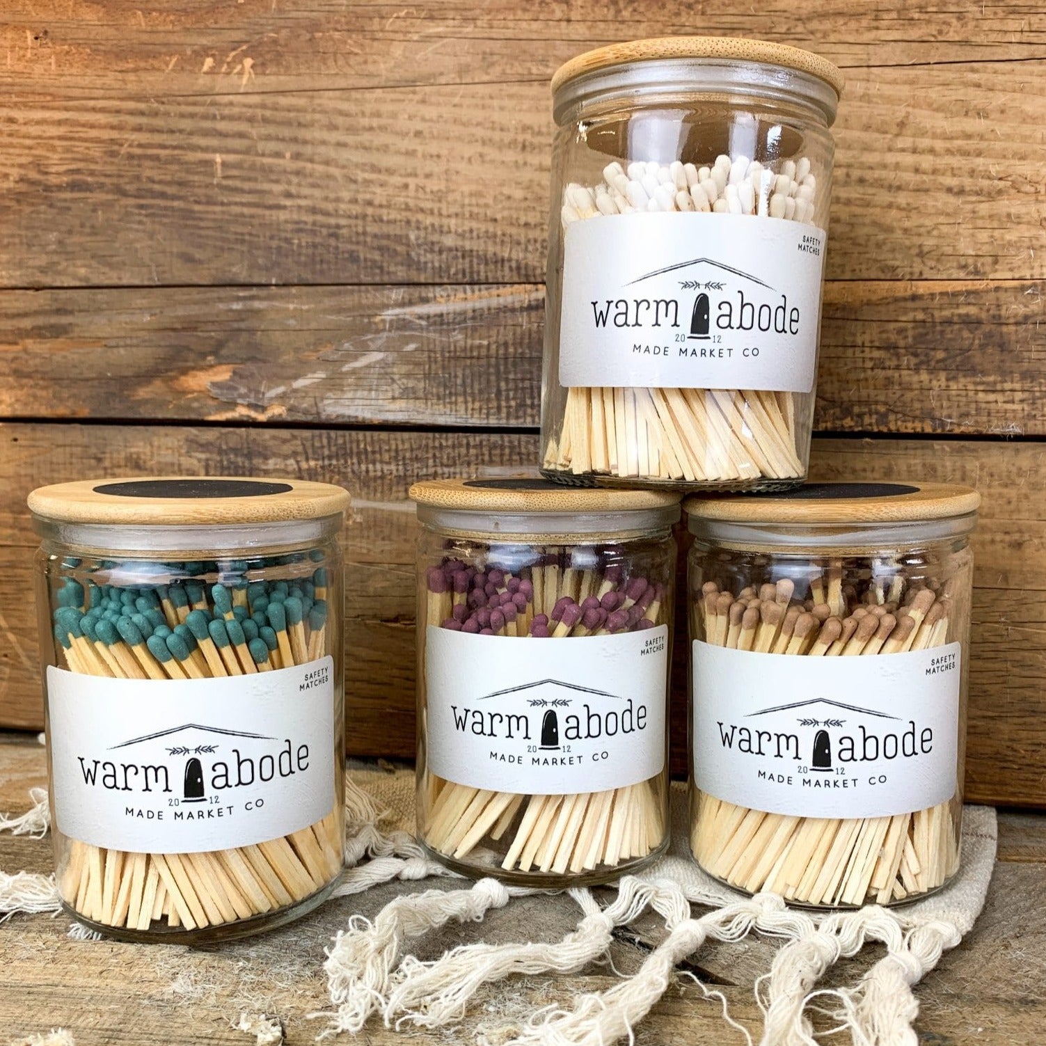 green, dusty rose, camel and white safety matches in glass jars