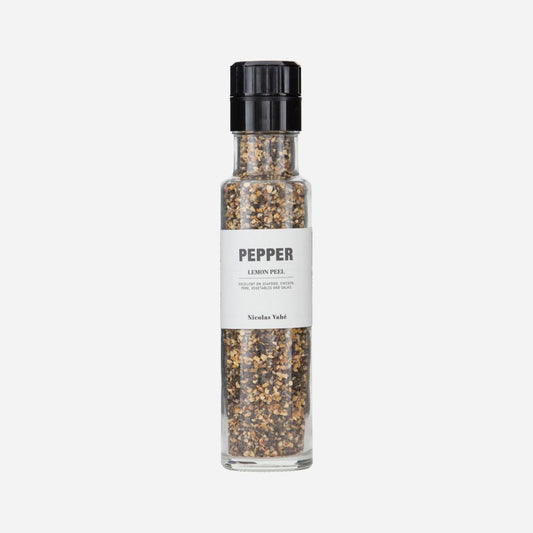 black pepper and lemon peel in a glass grinder bottle