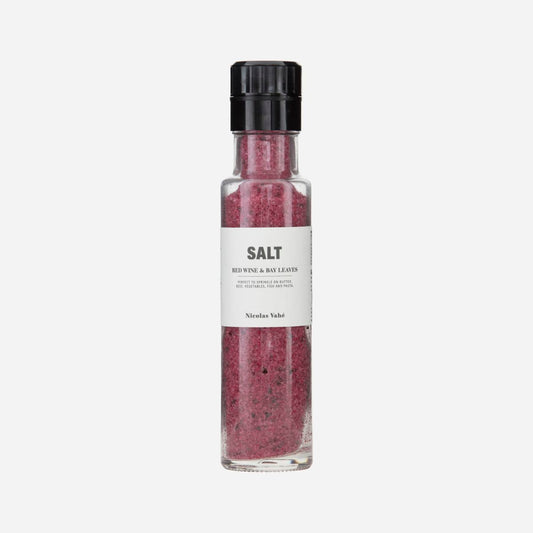 red salt with bay leaves in a glass grinder bottle